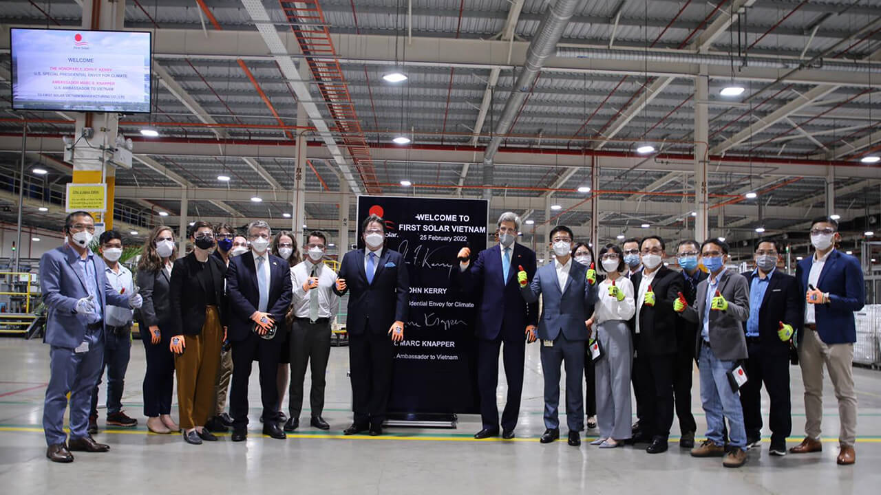 John Kerry and a group in a Vietnam factory